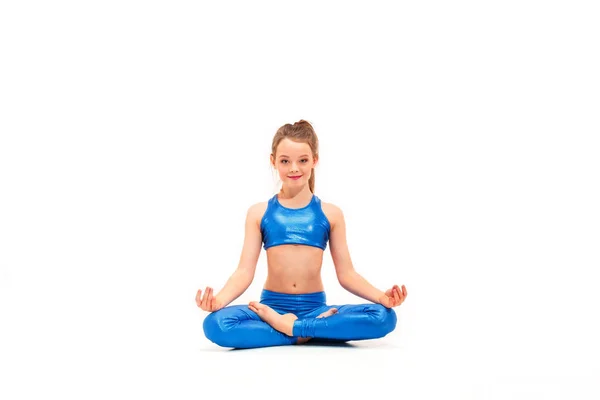 Studio shot of a young fit girl doing yoga exercises on white background — Stock Photo, Image