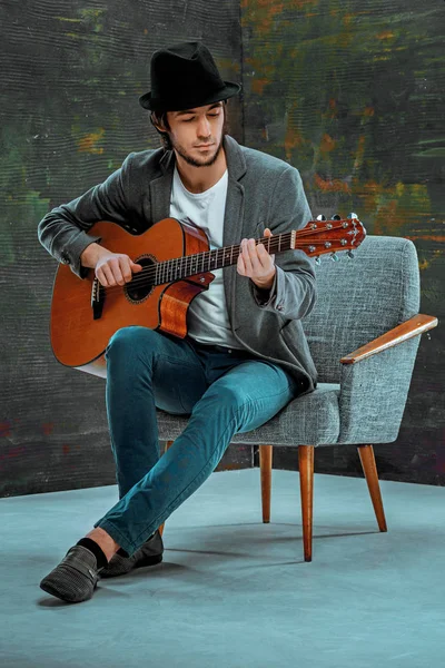 Cool guy with hat playing guitar on gray background — Stock Photo, Image