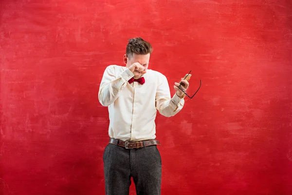 Retrato de homem perplexo falando por telefone um fundo vermelho — Fotografia de Stock