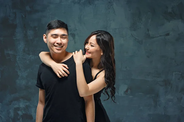 Портрет улыбающейся корейской пары на сером — стоковое фото