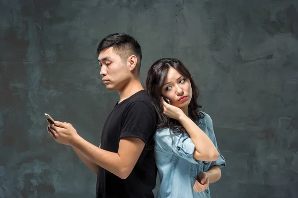 Asiatique jeune couple à l'aide de téléphone cellulaire, gros plan portrait . — Photo