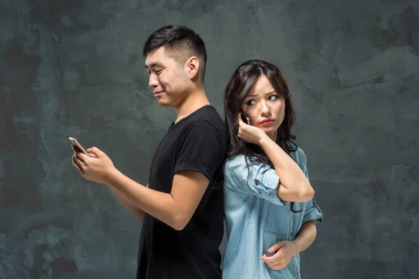 Asian young couple using cellphone, closeup portrait. — Stock Photo, Image