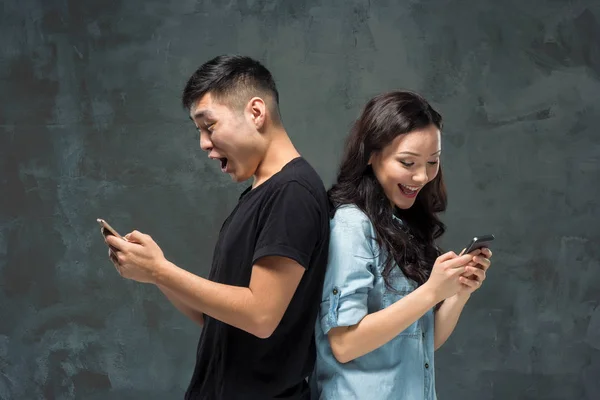 Asiatique jeune couple à l'aide de téléphone cellulaire, gros plan portrait . — Photo