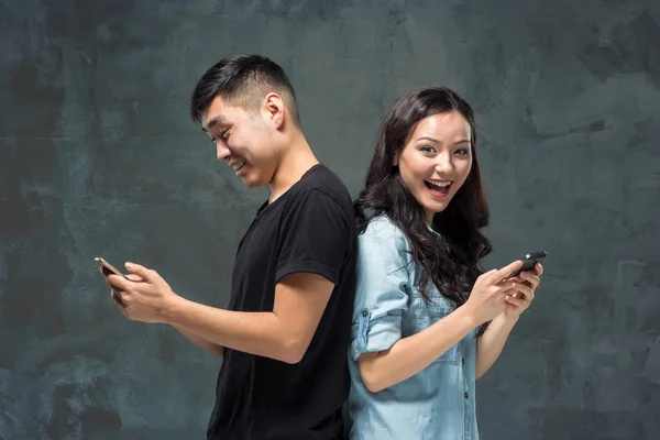 Asian young couple using cellphone, closeup portrait. — Stock Photo, Image