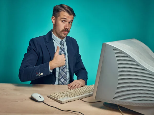 Portrait of cheerful young businessman sitting with computer — Stock Photo, Image