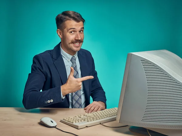 Retrato de jovem empresário alegre sentado com computador — Fotografia de Stock