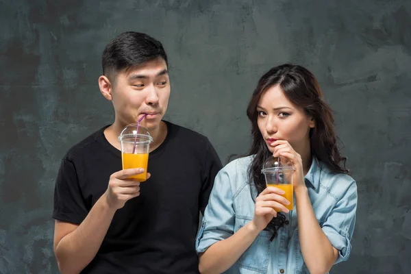 一对年轻漂亮的亚洲夫妇，带着一杯橙汁 — 图库照片
