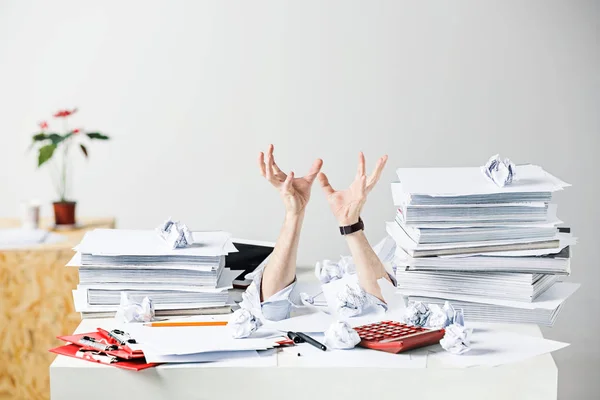 Os muitos papéis amassados na mesa do local de trabalho masculino estressado — Fotografia de Stock