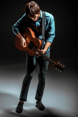 Cool adam gitar koyu arka plan üzerinde ayakta