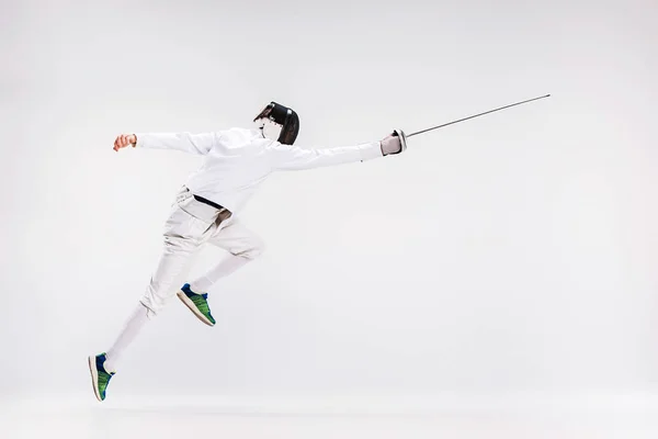 Hombre con traje de esgrima practicando con espada contra gris — Foto de Stock