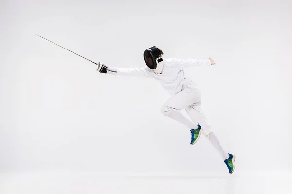 Hombre con traje de esgrima practicando con espada contra gris — Foto de Stock