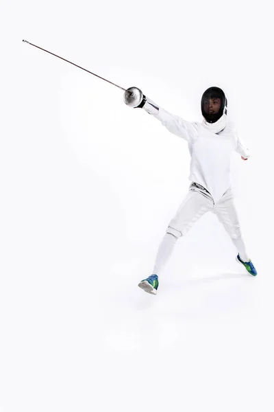 Hombre con traje de esgrima practicando con espada contra gris — Foto de Stock