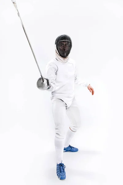 Hombre con traje de esgrima practicando con espada contra gris — Foto de Stock