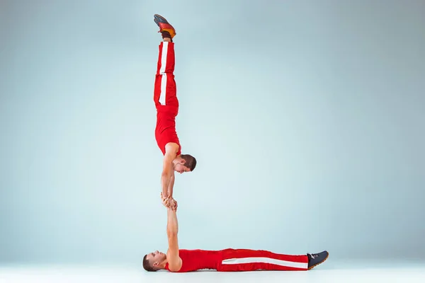 Les deux hommes acrobatiques gymnastique caucasiens sur la pose d'équilibre — Photo