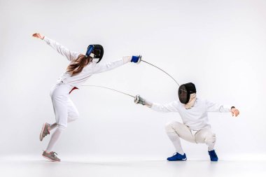 Kadın ve eskrim giyen adam gri karşı kılıç ile çalışmaya uygun