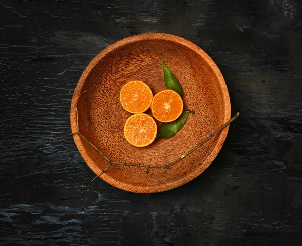 Las naranjas cítricos mitades en plato de madera — Foto de Stock