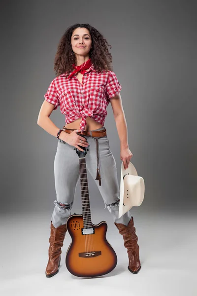 Die Cowgirl-Mode-Frau vor grauem Hintergrund — Stockfoto