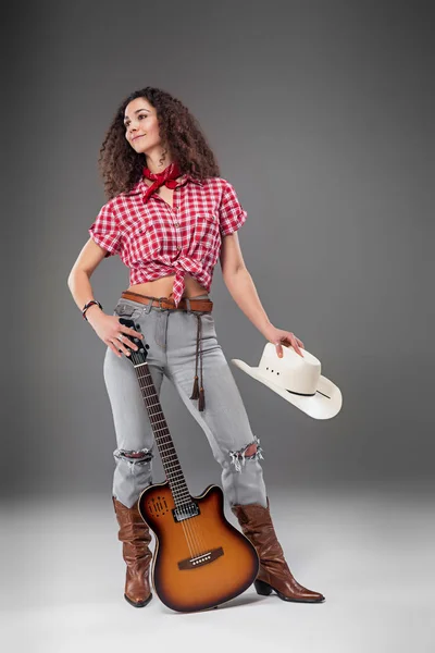 Die Cowgirl-Mode-Frau vor grauem Hintergrund — Stockfoto