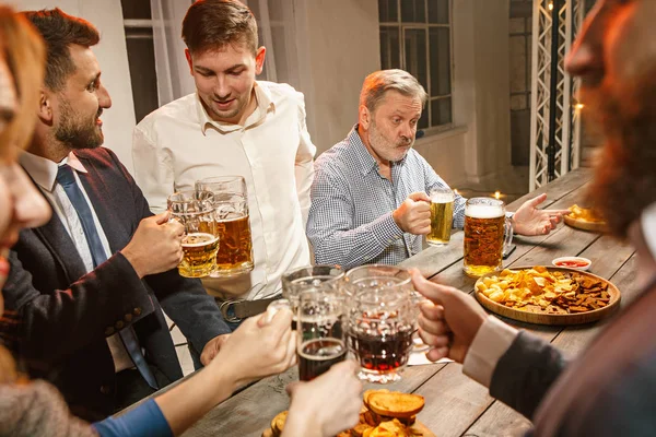 Grupo de amigos disfrutando de bebidas por la noche con cerveza —  Fotos de Stock