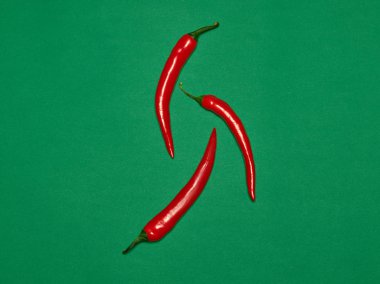 Acı biber ve yeşil bir arka plan üzerinde kırmızı biber