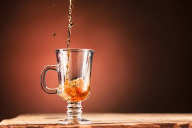 Brown kahverengi bir arka plan üzerinde çay içecek dışarı su sıçramalarına