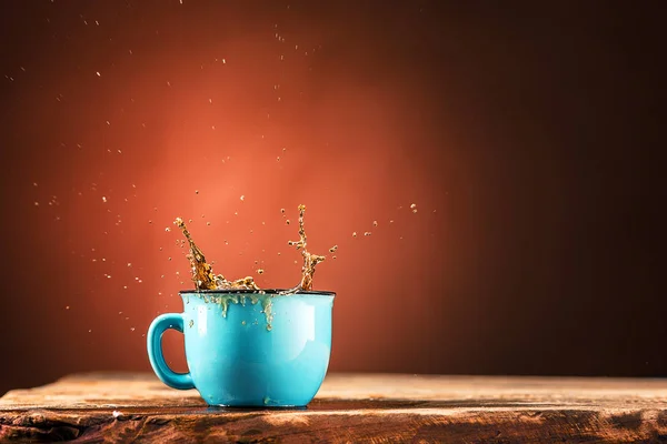 Brown espirra bebida da xícara de chá em um fundo marrom — Fotografia de Stock