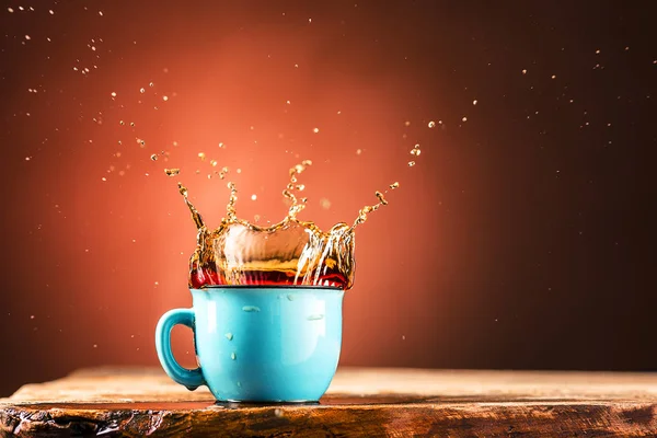 Brown espirra bebida da xícara de chá em um fundo marrom — Fotografia de Stock