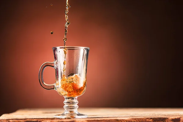 Brown spatten uit het drinken van een kopje thee op een bruine achtergrond — Stockfoto