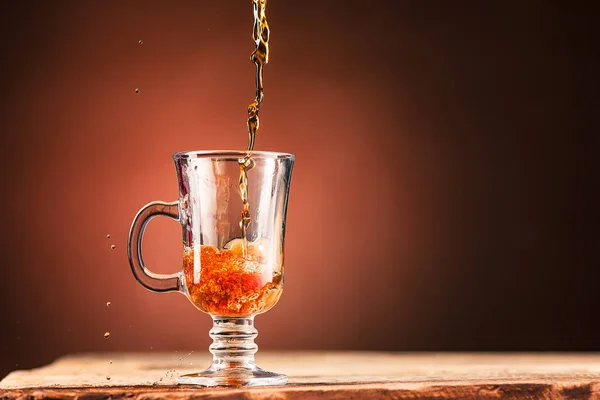 Bruna stänk ut drink från kopp te på brun bakgrund — Stockfoto