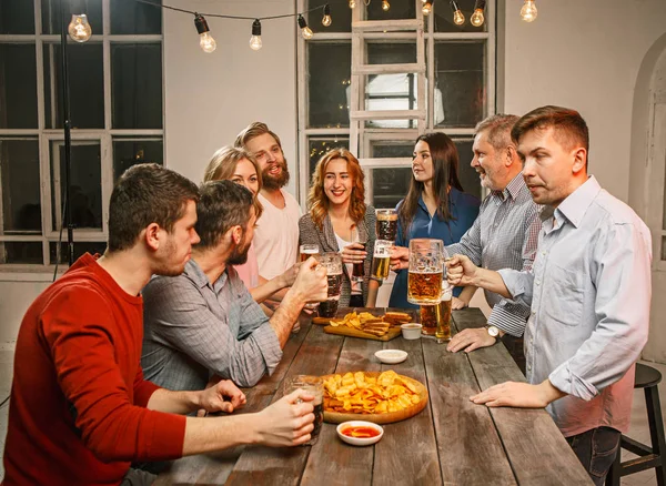 Grupo de amigos disfrutando de bebidas por la noche con cerveza — Foto de Stock