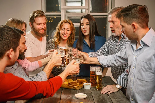 Grupo de amigos disfrutando de bebidas por la noche con cerveza — Foto de Stock