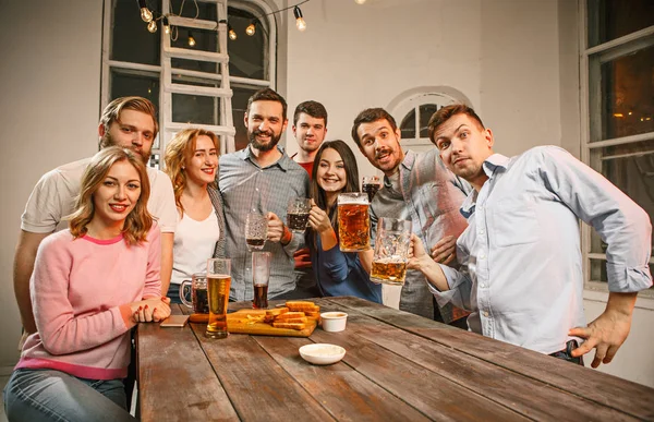 Groep vrienden genieten van de avond drankjes met bier — Stockfoto