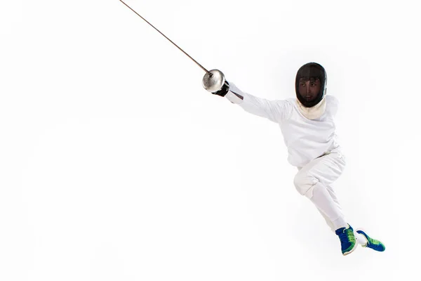 Человек в костюме фехтовальщика, практикующийся с мечом против серого — стоковое фото