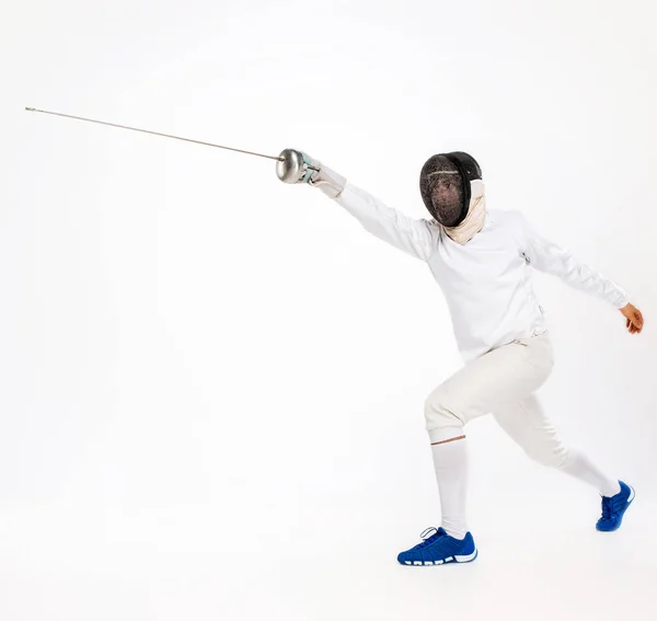 Hombre con traje de esgrima practicando con espada contra gris — Foto de Stock