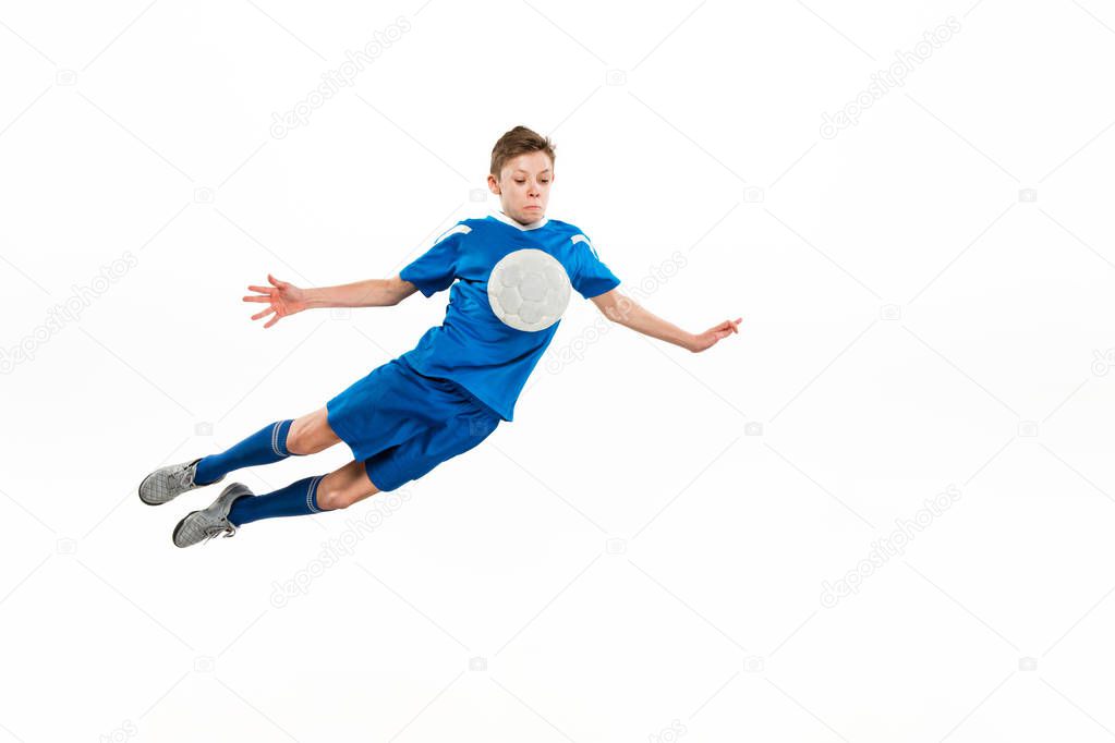 Young boy with soccer ball doing flying kick