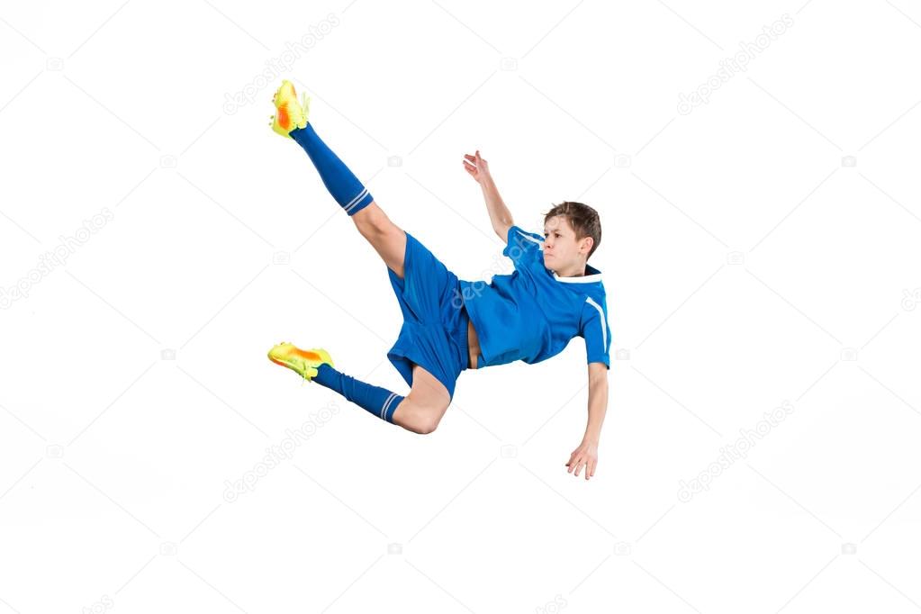 Young boy with soccer ball doing flying kick