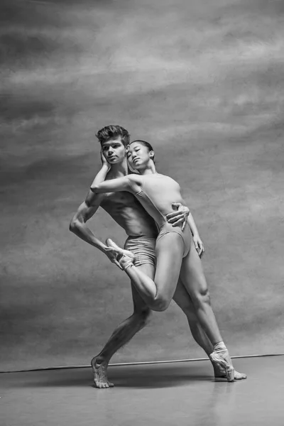 Pareja de bailarines de ballet posando sobre fondo gris — Foto de Stock