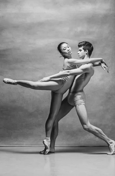 Casal de bailarinos posando sobre fundo cinza — Fotografia de Stock