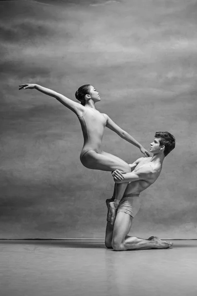 Pár baletních tanečníků vystupují nad šedým pozadím — Stock fotografie