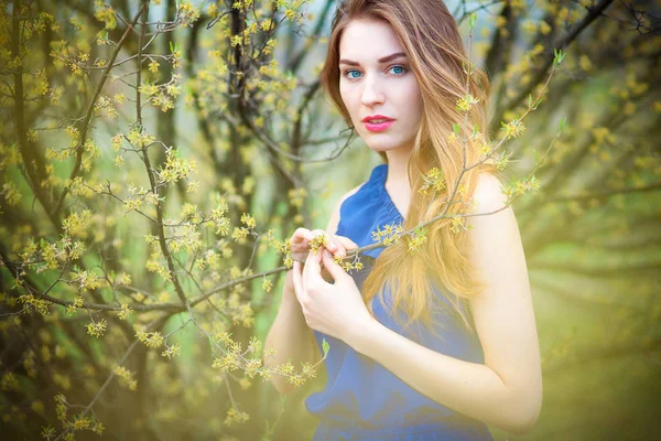 Mooie blonde vrouw in het park op een warme lentedag — Stockfoto