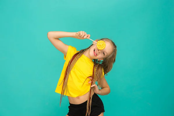 The teen girl with colorful lollipop on a blue background — Stock Photo, Image