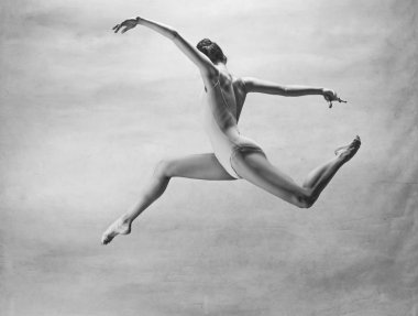 genç güzel modern stil dansçı bir stüdyo arka plan üzerinde atlama