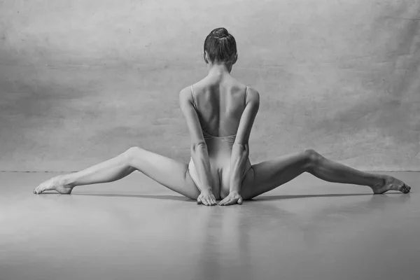 The ballerina is sitting with her back legs wide apart — Stock Photo, Image