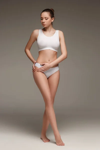 Junge, schlanke, gesunde und schöne Frau in weißen Dessous — Stockfoto