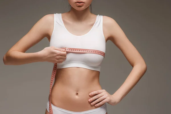 Flickan som mäter sin kropp, vit bakgrund. — Stockfoto
