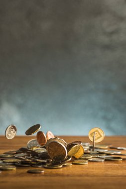 Gümüş ve altın sikkeler ve ahşap masa arka plan üzerine düşen paraları