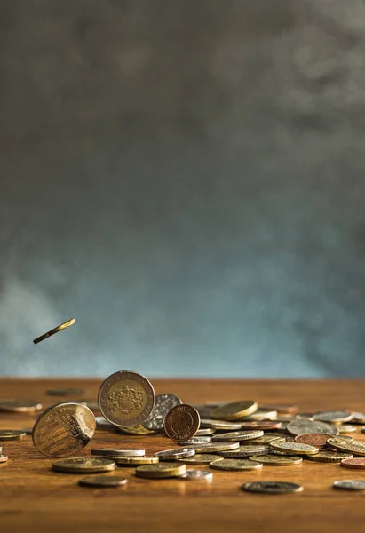 Las monedas de plata y oro y las monedas que caen sobre fondo de madera — Foto de Stock