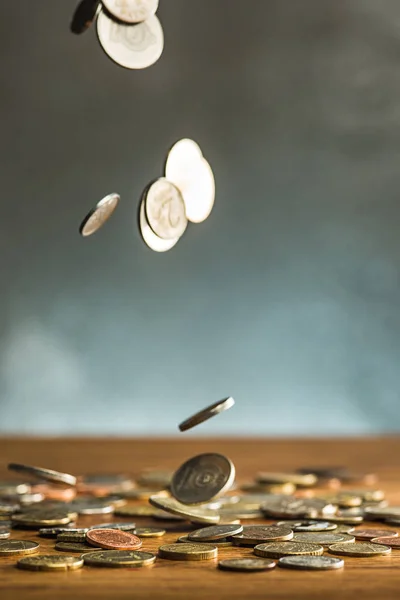 The silver and golden coins and falling coins on wooden background — Stock Photo, Image