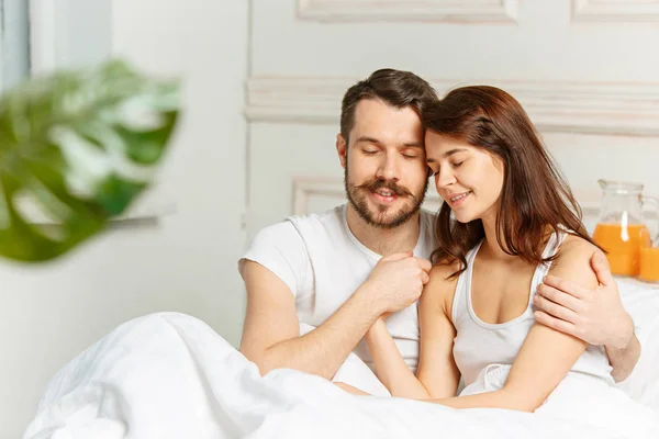 Joven pareja heterosexual adulta acostada en la cama en el dormitorio —  Fotos de Stock