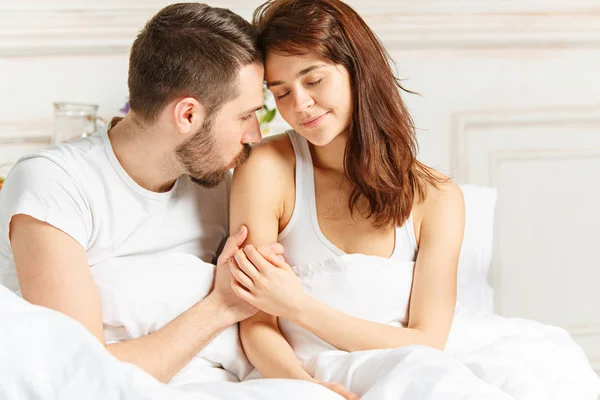 Fiatal felnőtt heteroszexuális pár ágyon a hálószobában — Stock Fotó